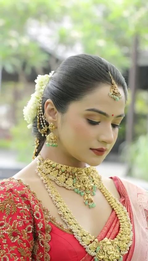 Bride with jasmine in her hair and a gold necklace